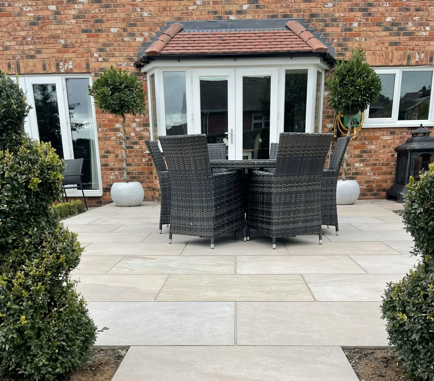 Stone patio with rattan furniture outside french doors